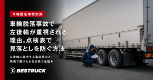 大型トラックの左後輪を点検する整備担当者