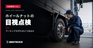 大型トラックのホイールナットを目視点検する作業員